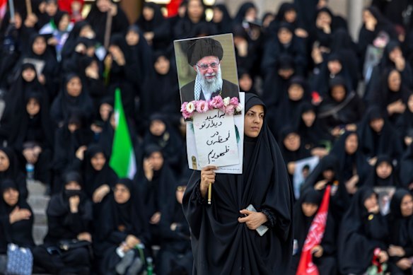 A woman holds a poster as people gather at the Imam Khomeini Grand Mosalla for a farewell ceremony for Iran's late Ayatollah Ali Khamenei.
