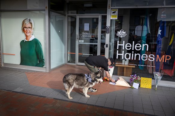 A man lays flowers outside Helen Haines’ office in Wangaratta.