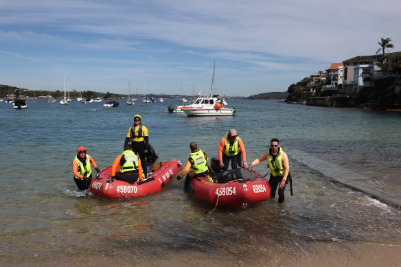 Rescue workers responsible for freeing an entangled whale arrive at Little Manly Beach.