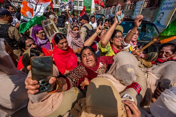 Indian police women stop opposition party members shouting anti-government slogans, as they tried to march on roads during the protest.