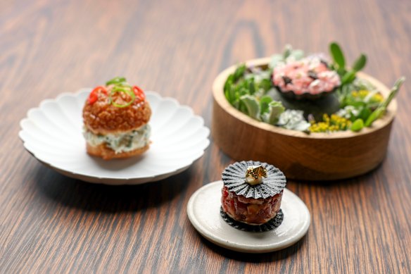 Opening snacks are a highlight, perhaps (clockwise from left) spanner crab and yuzu in a choux pastry bun; tuna belly with nori and finger lime; wagyu tartare with white miso and gold leaf.