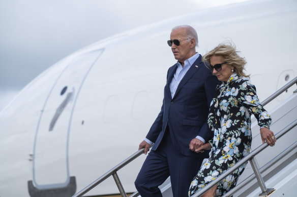 US First Lady Jill Biden holds President Joe Biden’s hand and they descend from Air Force One.