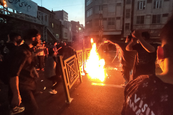 Protesters make fire and block the street during a protest over the death of a woman who was detained by the morality police, in downtown Tehran, Iran.