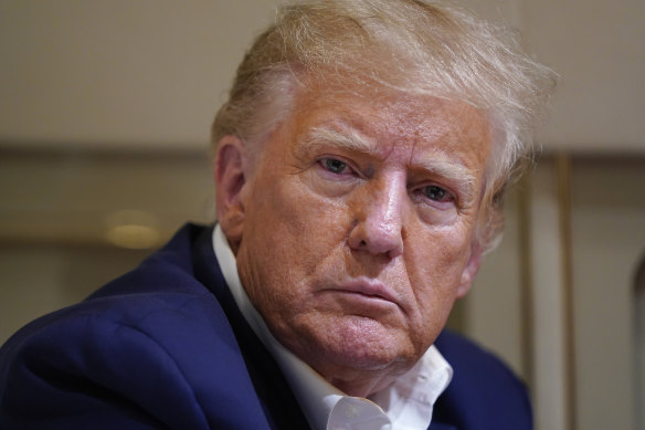 Former President Donald Trump listens as he speaks with reporters while in flight on his plane after a campaign rally last weekend.