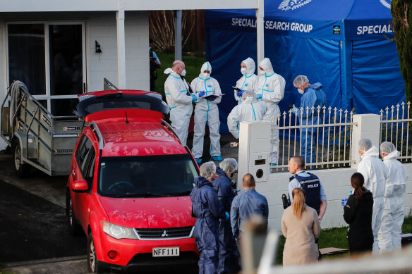 New Zealand police investigators working at a scene in Auckland on August 11, 2022, after bodies were discovered in suitcases.