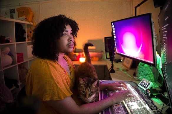 Ezra Burke, pictured with their cat, Patrice, bought a ChatGPT subscription when their NDIS support for psychotherapy was cut, and feels conflicted about using it. 