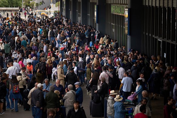 People waiting outside a closed train station during a  major power outage in Barcelona, Spain.