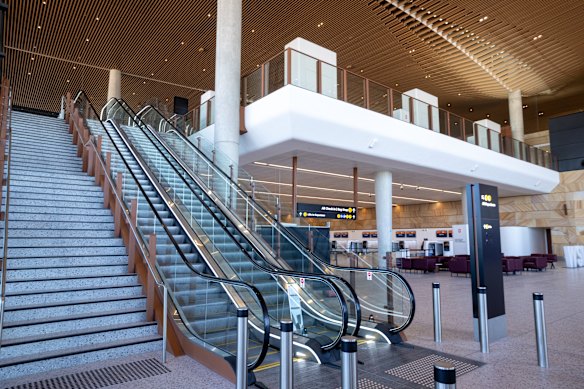 Escalators and stairs link a bag-drop area to departures on the first level.