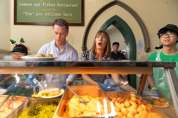 O primeiro-ministro Chris Minns e a parlamentar de Summer Hill, Jo Haylen, servem comida no dia de Natal. 