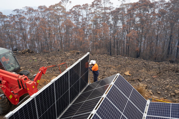 Workers install a solar and storage unit in bushfire hit Peak Alone, near the NSW town of Cobargo, provided by the Resilient Energy Collective.  