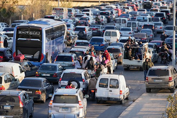 Displaced people fleeing Israeli strikes in southern Lebanon sit in traffic at a highway link to Beirut.