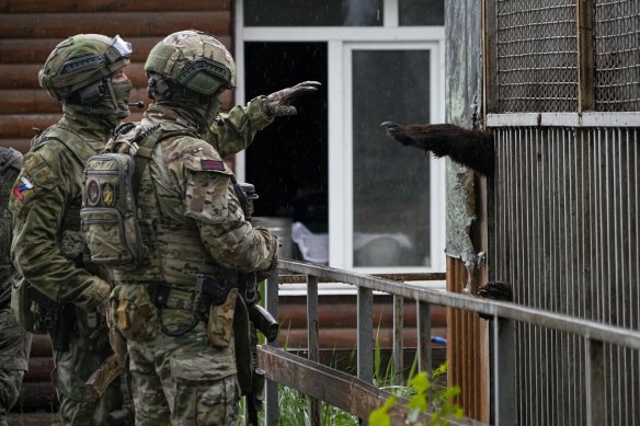 Russian soldiers play with a bear at the zoo in the now occupied city of Mariupol. 