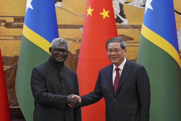 Solomon Islands Prime Minister Manasseh Sogavare, left, shakes hands with his Chinese counterpart Li Qiang  in Beijing, July 2023.