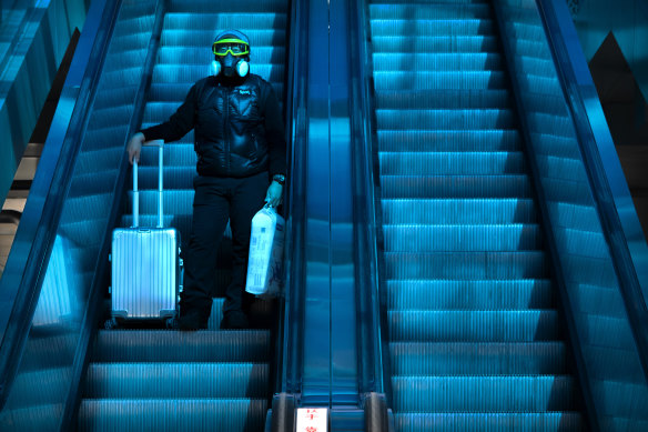 A lone passenger rides on an escalator beneath a coloured skylight at the Beijing Railway Station, which was largely quiet on the first day of the travel rush following efforts to dissuade migrants from travelling to curb the spread of COVID-19.   