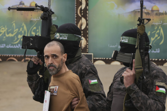 Israeli captive Eli Sharabi, taken hostage by Hamas on October 7, 2023, is escorted by Hamas fighters before being handed over to the Red Cross in Gaza.