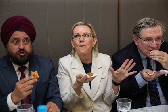 Opposition Leader Sussan Ley with Gurmeet Singh Tuli (left), the president of Little India Australia, and opposition immigration minister Paul Scarr, eating Indian food on Sunday in Sydney.