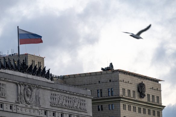 A bird flies over the building of the Russian Defence Ministry with anti-aircraft artillery systems atop.