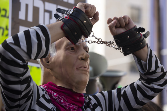 A protester wears a mask representing Israeli Prime Minister Benjamin Netanyahu outside the District Court in Jerusalem.