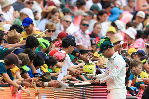 David Warner signs autographs.