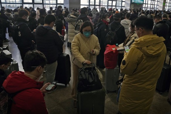 Lunar New Year holidaymakers wait to catch their trains at the West Railway Station in Beijing on Sunday.