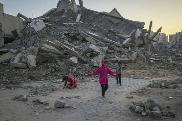 Palestinian children play next to a building destroyed by Israeli army strikes in the central Gaza Strip town of Khan Younis on January 1.