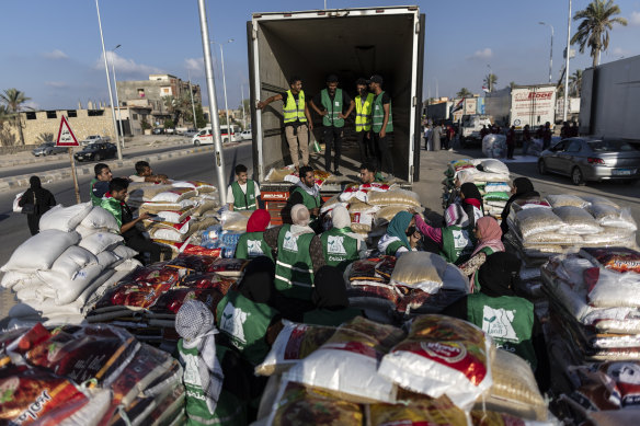Volunteers load food and supplies onto trucks in an aid convoy for Gaza in North Sinai, Egypt.
