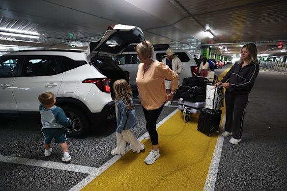 Jenny Papliakakis picks up her son Chris, daughter-in-law Eleni and grandchildren Pia and Nikolas at the new pick-up zone at Melbourne Airport. 