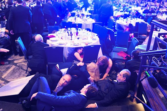 Guests take cover after gunshots were fired outside the Washington Hilton ballroom.