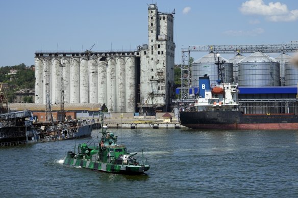 A Russian military boat guards an area with the grain storage in the background at the Mariupol Sea Port.