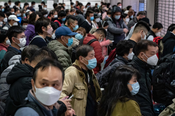 Travellers wait at a Hong Kong border checkpoint as tens of thousands surge into mainland China border as “COVID zero” ends after three years.