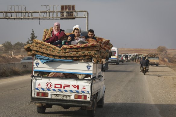 Residents leave the city carrying their belongings in the aftermath of the opposition’s takeover of Hama, Syria, on Friday.