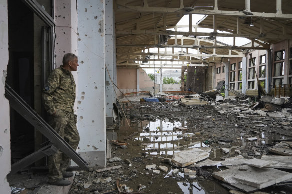 A Ukrainian serviceman looks at the ruins of the sports complex of the National Technical University in Kharkiv, damaged during a night of shelling.