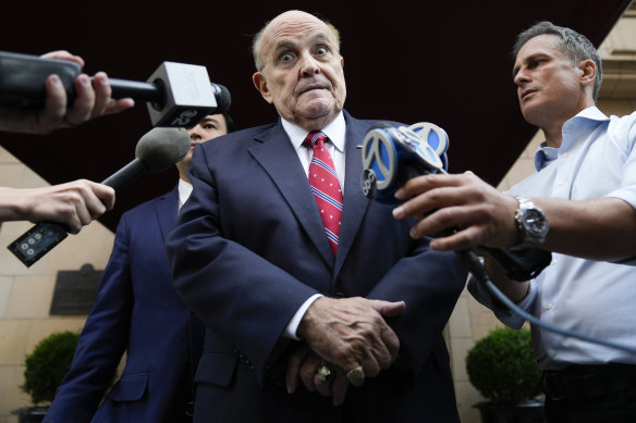 Former Mayor of New York Rudy Giuliani speaks to reporters as he leaves his apartment building in New York.