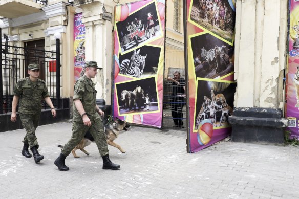 Russian soldiers walk past an area where the Wagner Group military company’s tank was parked near the headquarters of the Southern Military District in Rostov-on-Don at the weekend.