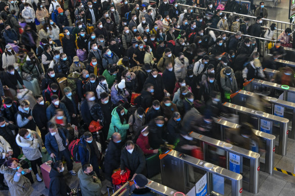 People wearing face masks line up to enter ticket counters to catch their trains in Suzhou in east China’s Jiangsu Province on Saturday.