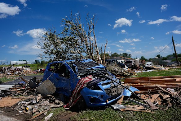 A vehicle is covered in debris after a severe storm.