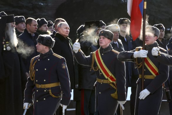 Rusya Devlet Başkanı Vladimir Putin, merkez solda, 12. ay dönümü arifesinde Moskova'daki “Vatan Savunucuları Günü” ulusal kutlamaları sırasında Kremlin Duvarı yakınlarındaki Meçhul Asker Mezarı'na çelenk koyma törenine katıldı. onun savaşından.