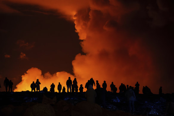 Onlookers watch the volcanic activity in Iceland from a distance on Saturday night.