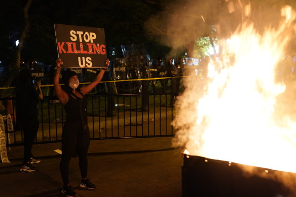 A fire burns in a dumpster near the White House as demonstrators protest the death of George Floyd.
