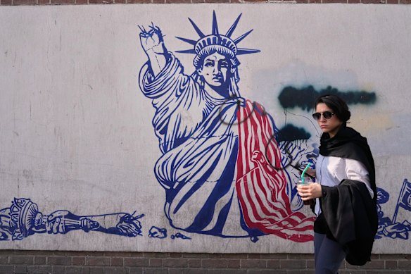 Venerdì una donna passa davanti a un murale anti-americano sul muro dell'ex ambasciata americana, ora museo, a Teheran.