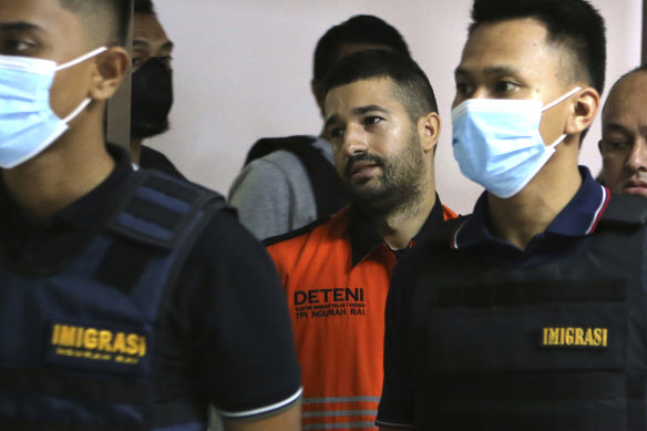 Immigration officers escorted Australian fugitive Antonio Strangio, center, to a press conference in Nusa Dua, Bali, Indonesia, Sunday, February 19.