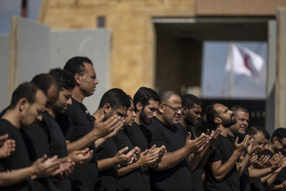 Volunteers and NGO staff pray at the Rafah border after a massive blast hit the Ahli Arab Hospital Hospital in Gaza in North Sinai, Egypt. 