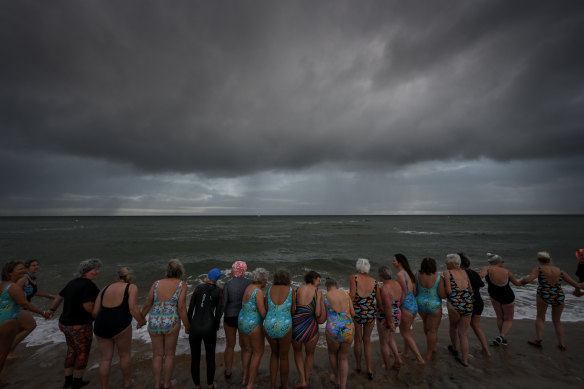 Braced for the cold of the ocean, the ‘wolfies’ head into the sea at Mount Martha.