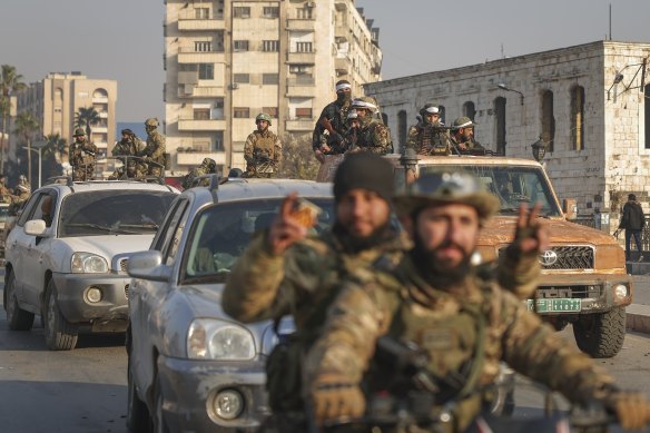 Syrian opposition fighters ride along the streets in the aftermath of the opposition’s takeover of Hama, Syria, on Friday.