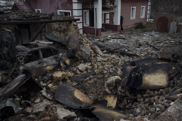 A Ukrainian firefighter and serviceman inspect a damaged house following a Russian drone attack in Stari Bezradychi, Kyiv region, on Monday.