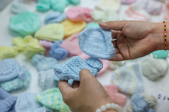 Tiny booties and a beanie made by volunteers at Treasured Babies in Mooroolbark.