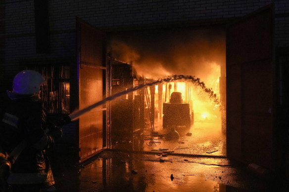 Ukrainian firefighters extinguish a blaze at a warehouse after a bombing in Kyiv, Ukraine.