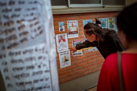 A man looks at photos of people reported missing.