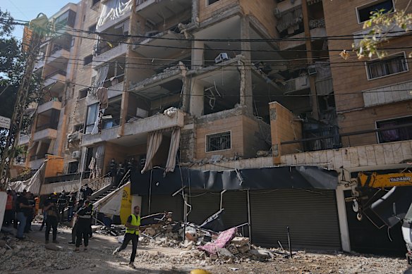 Lebanese security officers gather at the site where an Israeli airstrike hit a building in Dahiyeh.