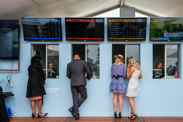 Racegoers place bets at the Birdcage during Stakes Day.